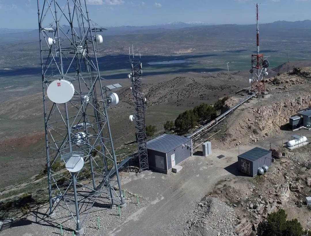 Drone view of towers and shelters on a mountaintop